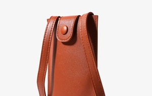 Detail view of mini phone bag featuring caramel faux leather and precise stitching