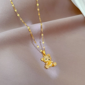 Detailed macro view of a gold teddy bear pendant necklace with sparkling pavé rhinestones