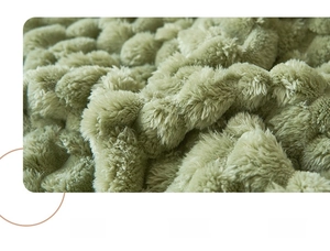 Detail of soft sage green plush blanket fabric featuring a unique 3D bubble texture