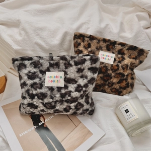 Detail of leopard print plush cosmetic bags in grey and brown with soft faux fur texture