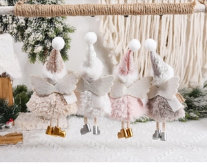 Detail of four plush Christmas angel ornaments hanging on a rustic rope with soft lighting