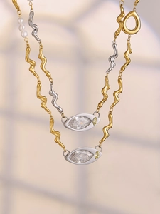 Macro shot of gold and silver wave-shaped chain with marquise stones and white pearls