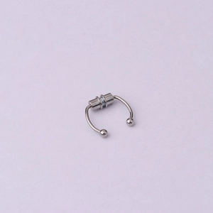 Polished silver magnetic non-piercing septum nose ring on lavender background