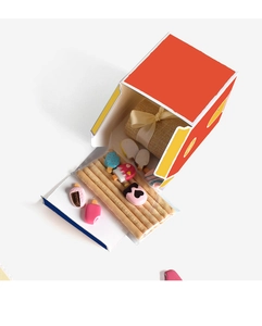 Detail of red geometric house gift box with ice cream accessories and burlap pouch