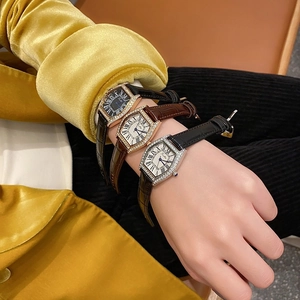 Close-up of elegant rectangular ladies' watches with diamond-set cases and leather straps