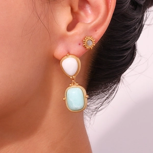 Detail of female model wearing gold titanium earrings with natural blue amazonite stones