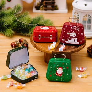 Close-up of mini Christmas tin suitcase boxes with Santa illustrations and candies