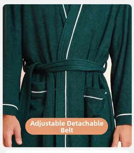 Detail of dark green towel bathrobe featuring white piping and adjustable removable waist belt