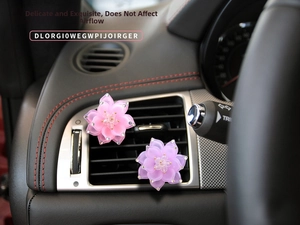 Detail of pink and purple rhinestone lotus vent clips on car air conditioning outlet