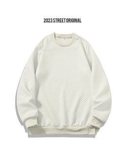 Nahaufnahme der gesteppten Rautenstruktur auf dem cremefarbenen Langarm-Sweatshirt