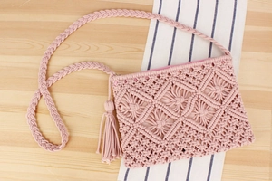 Detail of pink hand-woven cotton rope bag featuring geometric patterns and a long tassel