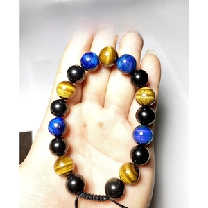 Bracelet de 10 mm en œil de tigre bleu et obsidienne noire, tenu à la main sur fond blanc