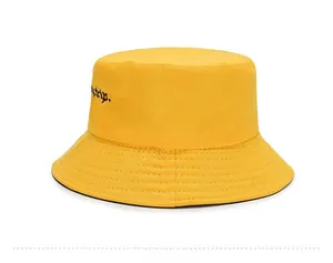 Detail view of bright yellow canvas bucket hat with black embroidery and reinforced stitching
