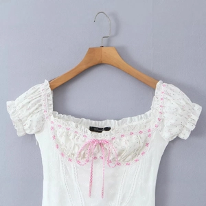Robe blanche à épaules dénudées avec broderie florale et détails en dentelle rose