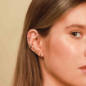 Detailed view of S925 silver ear cuff and black gemstone studs set on a model ear