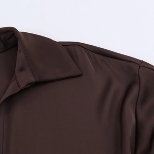 Detailed macro shot of silky dark brown satin fabric texture on collar and shoulder