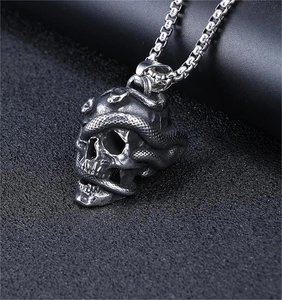 Macro shot of punk style snake and skull pendant with detailed scales and round box chain