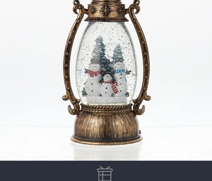 Close-up of bronze snow globe lantern featuring three snowmen and holiday trees