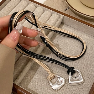 Collana lunga minimalista in corda intrecciata con pendente metallico geometrico