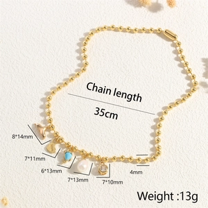 Detailed view of golden bead chain with dolphin tail, zircon, and pearl charms