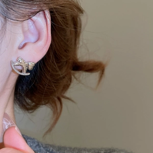 Gros plan d'élégante boucle d'oreille cheval à bascule en argent avec oxydes de zirconium