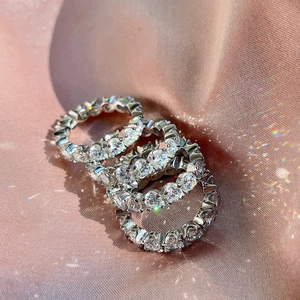 Three stacked s925 silver eternity rings featuring 5A cubic zirconia stones on silk fabric