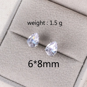 Detail shot of 6x8mm teardrop zircon earrings in silver setting on gray velvet