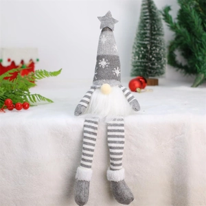 Close-up of a sitting Christmas gnome with a snowflake knit hat and striped long legs