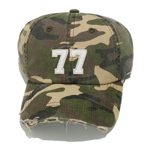 Close-up of distressed brim on camo baseball cap with white number 77 embroidery