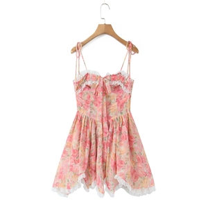 Detalle de minivestido floral rosa con ribete de encaje blanco y lazo decorativo