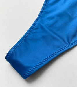 Detailed close-up of blue fitness thong with premium zigzag stitching and high elastic fabric