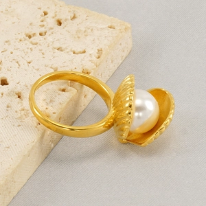 Elegant gold shell ring with white pearl on stone, minimalist luxury jewelry design