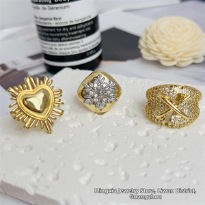Macro view of 18K gold plated heart and floral zircon rings on a stone tray