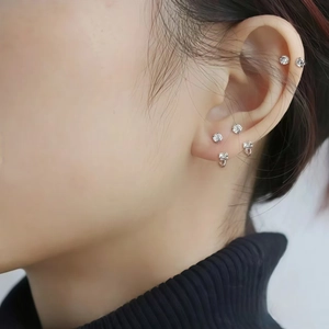 Close-up of multiple zircon-studded titanium horseshoe rings on the ear