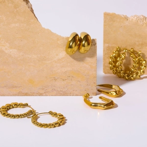 Minimalist 18K gold plated bamboo twist hoop earrings set on natural stone stand