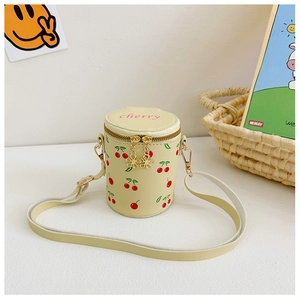 Detail of beige cylinder bucket bag featuring red cherry prints and golden zippers