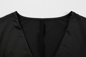 Detailed close-up of the V-neckline with high-quality stitching on a black fitted dress