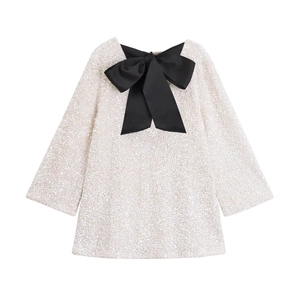 Sparkly white sequin dress with a large black satin bow collar, long sleeve design