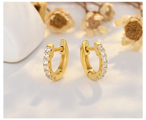 Close-up of gold-plated hoop earrings with micro-pave white zircons and stud texture