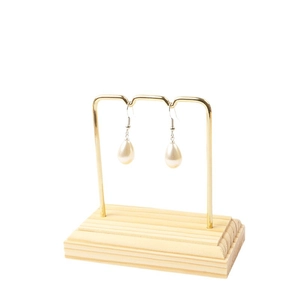 Water drop pearl earrings displayed on a gold metal stand with a natural wooden base
