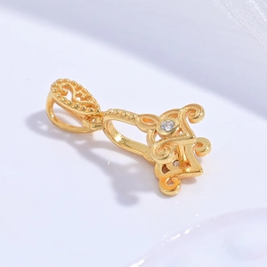 Macro detail of golden clover pendant with white zircon and retro hollowed pattern