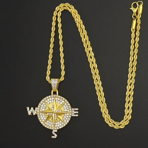 Gros plan du pendentif boussole doré avec cristaux brillants et chaîne torsadée