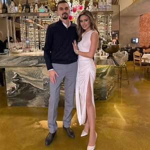 Sleeveless white asymmetrical slit dress with elegant pleats in a luxury restaurant