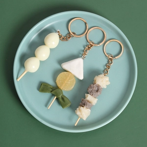 Portachiavi realistici con spiedini di cibo Oden su un piatto di ceramica blu