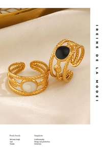 Close-up of vintage adjustable gold rings with woven bands and shell inlays on silk