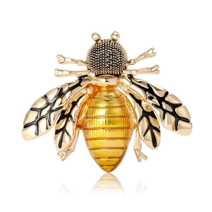 Elegant gold-tone bee brooch with black enamel wings and amber resin body on white background