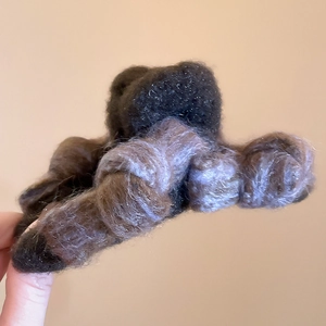 Close-up of a large flocking bow hair claw in dark brown and light purple mixed fur