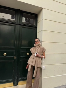 Détail d'un gilet en fausse fourrure beige avec col montant et ceinture à nouer