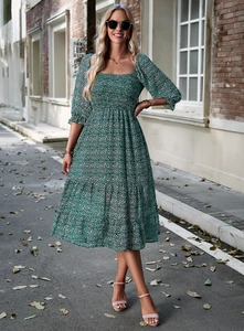 Full-body shot of a green floral maxi dress with square neck and pleated bodice details