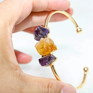 Detailed shot of gold plated cuff with raw amethyst and citrine quartz stones